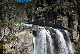 Majestic Johnston Canyon Waterfall with Rainbow in Rocky Mountains