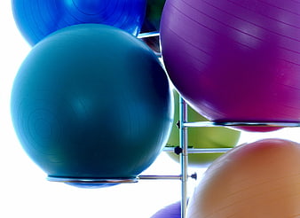 Colorful Exercise Balls on Metal Rack in Gym