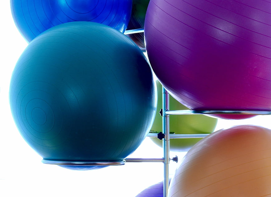 Colorful Exercise Balls on Metal Rack in Gym