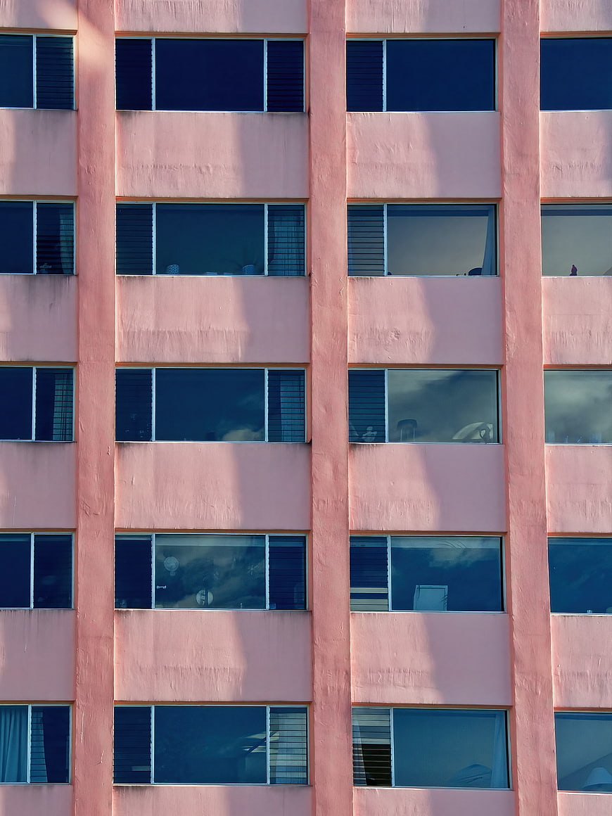 Pink Apartment Building Facade with Blue Windows