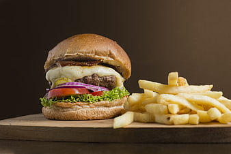 Gourmet Cheeseburger With Melted Cheese And French Fries On Wooden Board