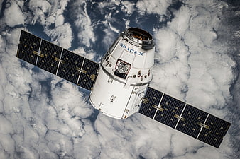 SpaceX Dragon spacecraft orbiting Earth with solar panels