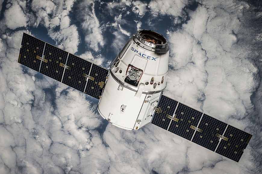 SpaceX Dragon spacecraft orbiting Earth with solar panels