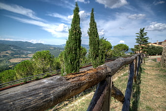 Rustic wooden fence overlooking Tuscan hills and cypress trees
