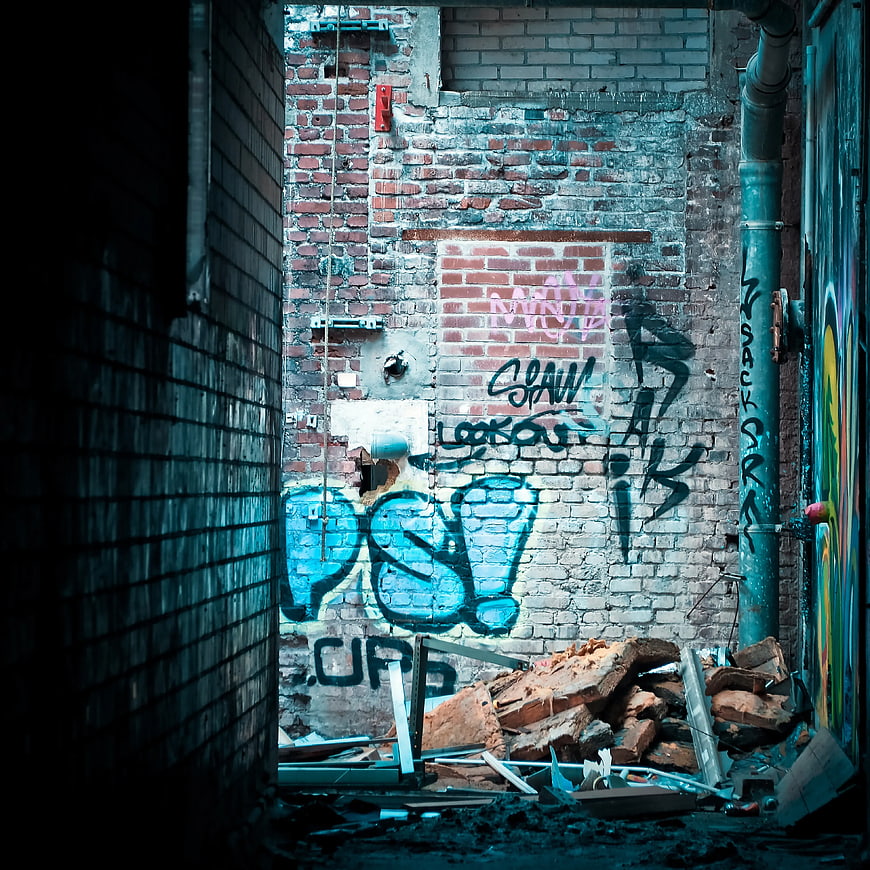 Urban Graffiti on Weathered Brick Wall in Alley