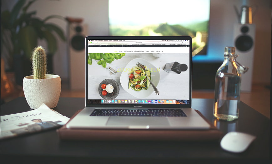 Laptop on Desk with Cactus and Water Bottle