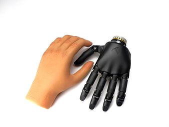 Human Hand Touching Black Robotic Prosthetic Hand on White Background