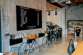 Industrial coffee shop interior with bicycles and menu board