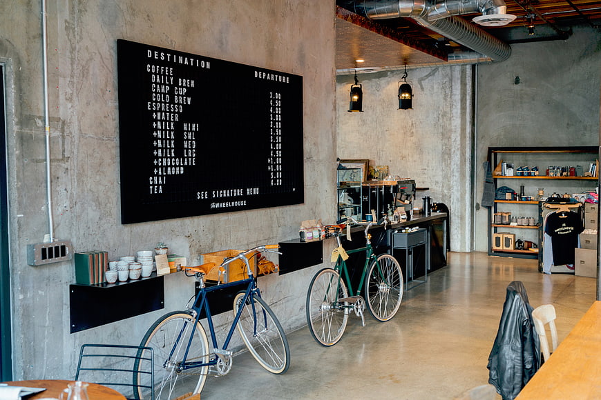 Industrial coffee shop interior with bicycles and menu board