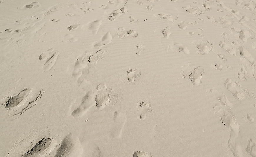 Footprints in white sand beach texture background