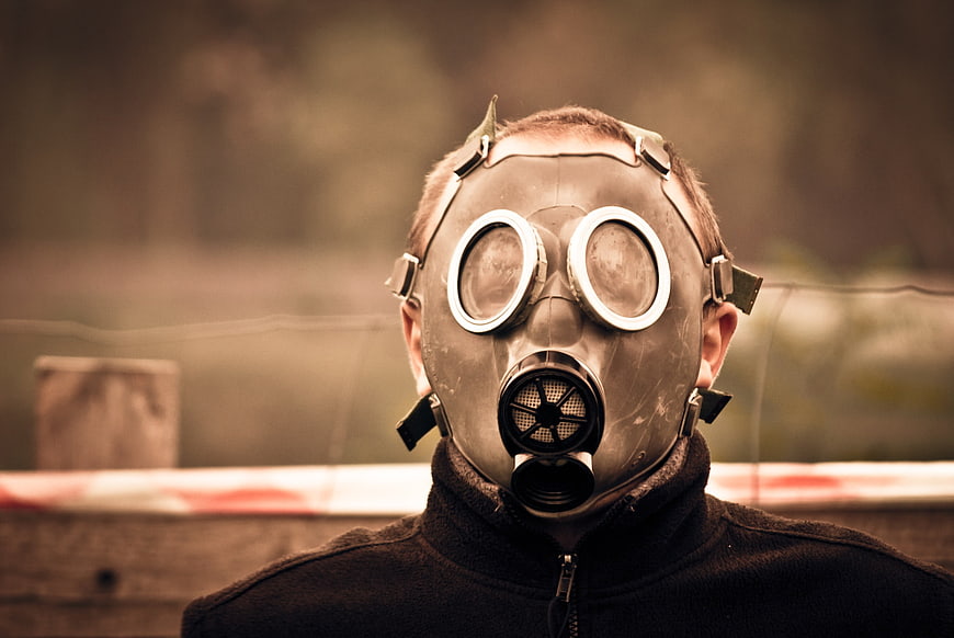Man Wearing Vintage Gas Mask in Post-Apocalyptic Setting