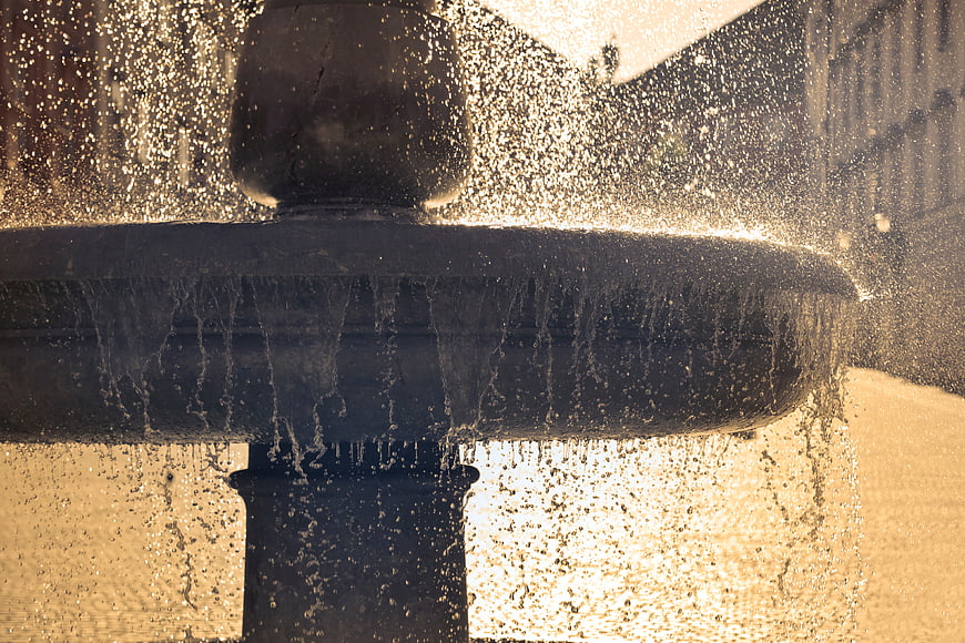 Close-up of water fountain spray in golden sunlight
