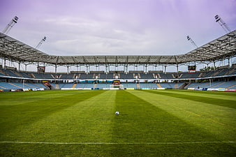 Empty Soccer Stadium with Ball on Green Grass Field