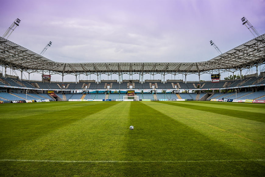 Empty Soccer Stadium with Ball on Green Grass Field