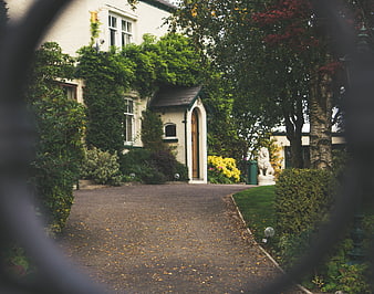 Charming House Entrance Viewed Through Garden Gate