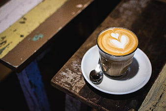 Latte art cappuccino on rustic wooden table