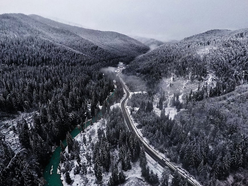 Aerial View of Snowy Mountain Road and Turquoise River