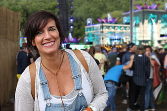 Smiling Woman at Outdoor Music Festival with Crowd