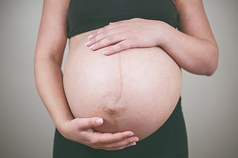 Pregnant Woman Holding Round Belly With Both Hands