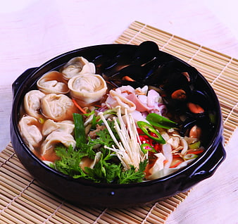 Korean Mandu Dumpling Soup with Mushrooms and Vegetables in Black Bowl