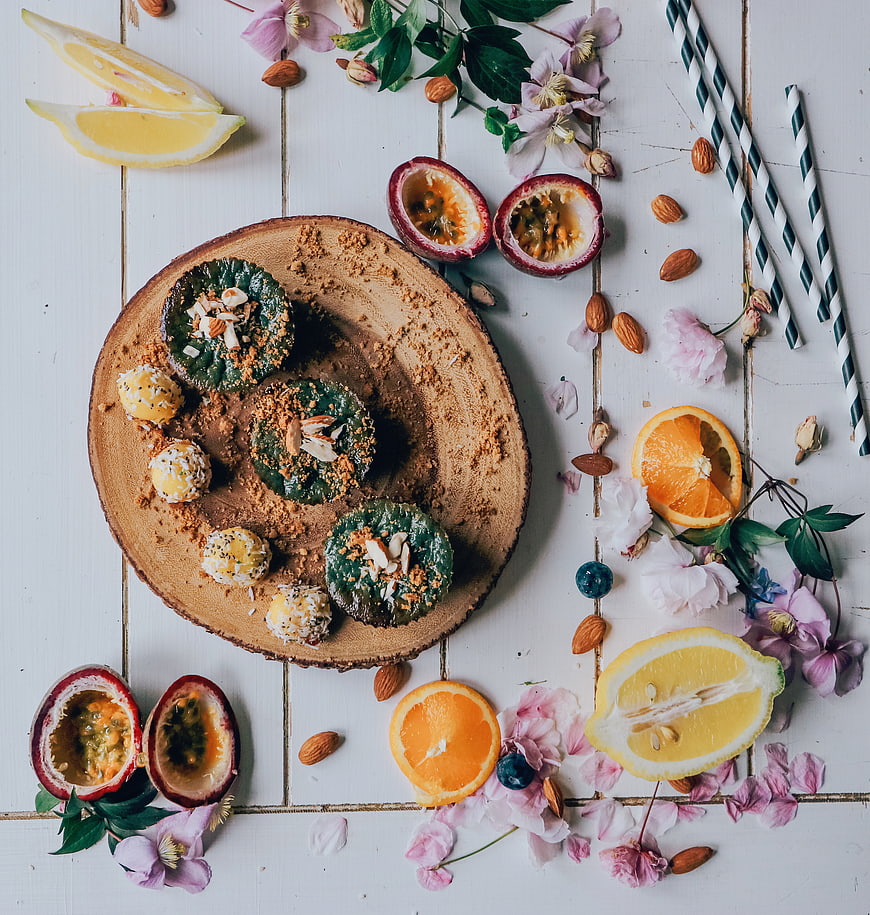 Flat lay of green cupcakes with passion fruit and citrus on wood