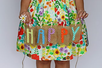 Woman holding happy banner in floral dress