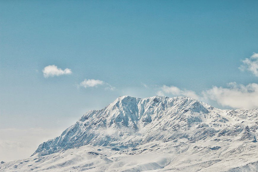 Snow-Capped Mountain Peak Against Clear Blue Sky