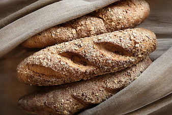 Freshly baked whole wheat bread loaves on linen cloth