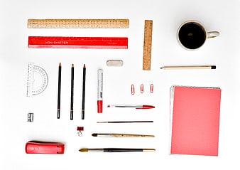 Flat lay of red and black stationery with coffee on white background