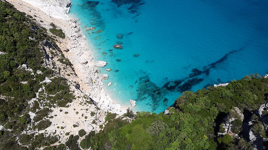 Aerial View of Turquoise Sea and Rocky Cliffside Beach