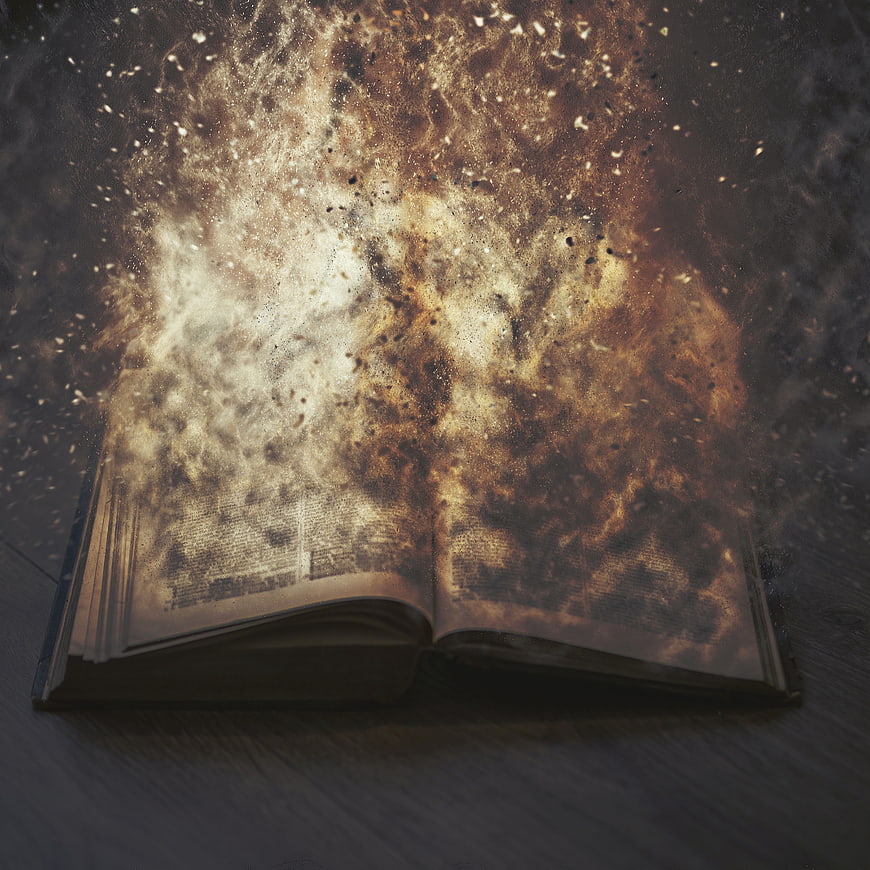 Open book with magical golden dust and sparks rising