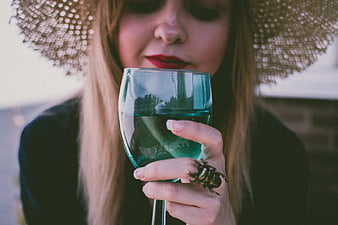 Woman in Straw Hat Holding Blue Wine Glass