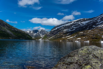 Scenic Alpine Lake with Snow-Capped Mountains and Blue Sky