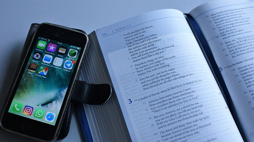Smartphone and Open Tehillim Book on Blue Surface