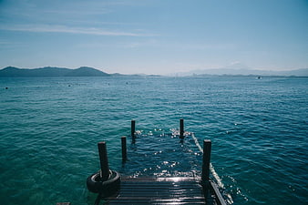 Submerged wooden pier in turquoise ocean water