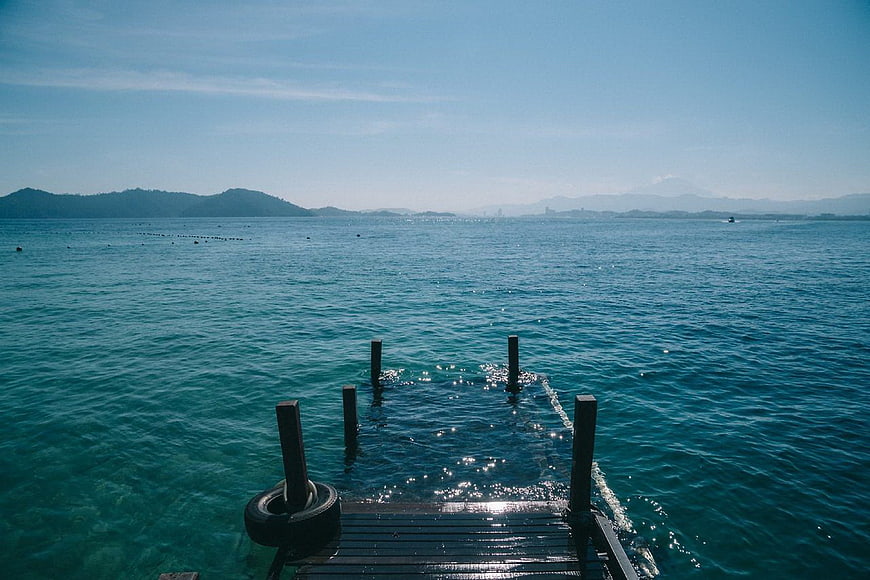 Submerged wooden pier in turquoise ocean water