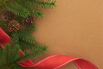 Christmas Pine Branches and Red Ribbon on Brown Background