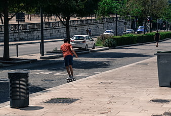 Young Man Skateboarding Downhill on Urban Street