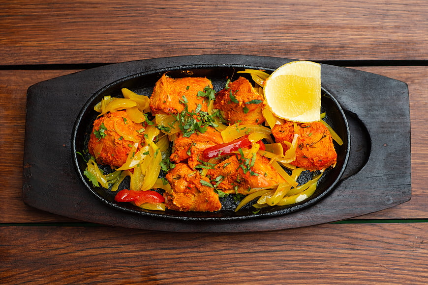 Tandoori Chicken Tikka Served in Cast Iron Skillet on Wooden Table