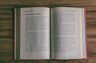 Open book on wooden table about marketing and self-promotion