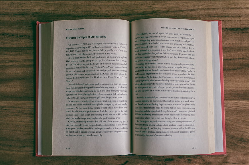 Open book on wooden table about marketing and self-promotion
