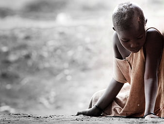 Sad young African child sitting alone in poverty