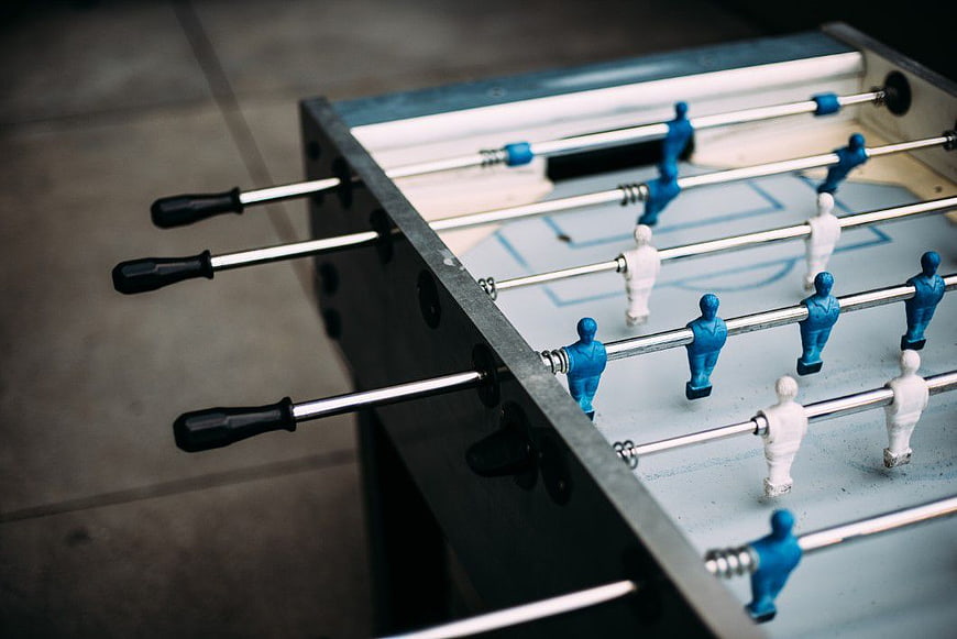 Close-up of blue and white foosball table players