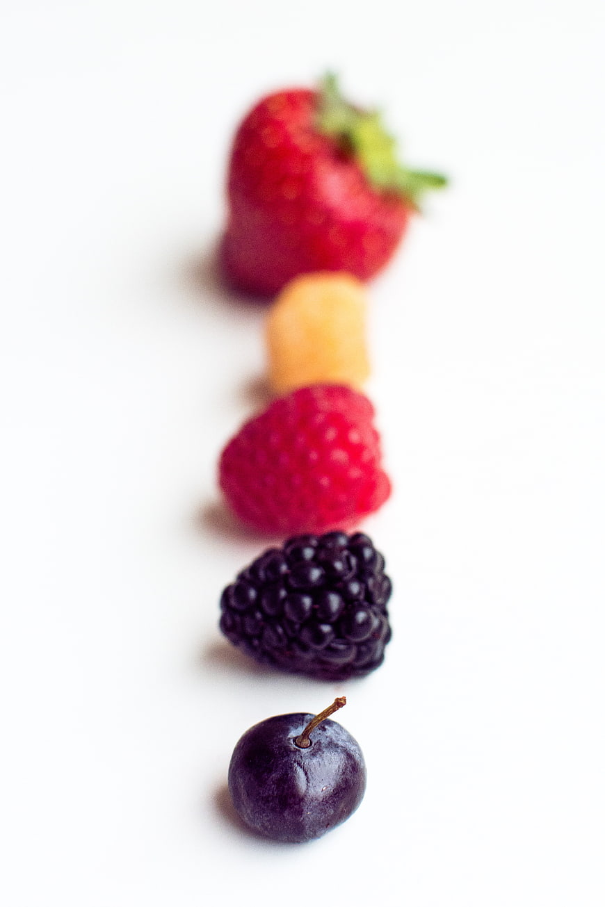 Vertical Line of Fresh Mixed Berries on White Background
