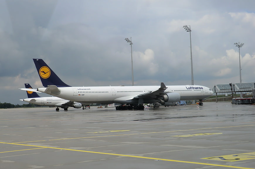 Lufthansa airplane parked on wet airport tarmac