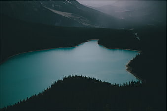 Aerial View of Turquoise Mountain Lake Surrounded by Dark Forest