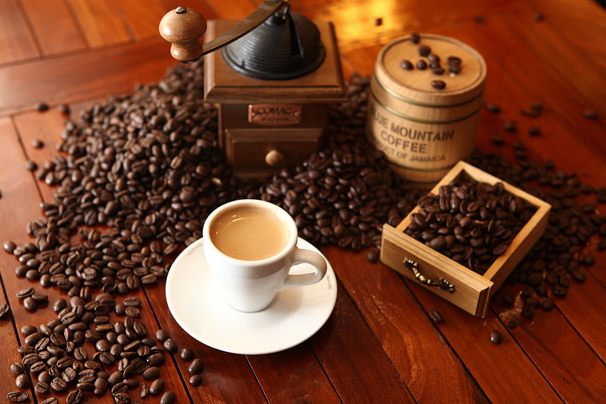 Rustic Coffee Still Life With Grinder, Beans, And Cup On Wooden Table
