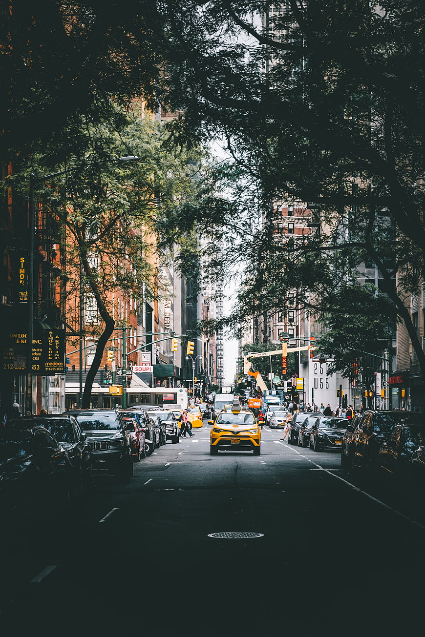 Yellow Taxi Driving Down Urban City Street
