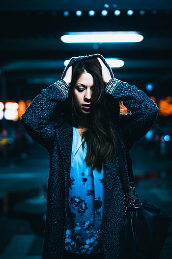 Woman holding head in distress at night