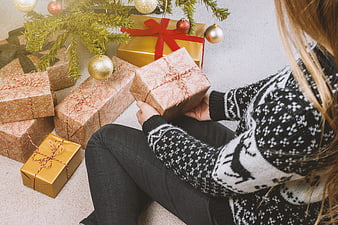 Woman Wrapping Christmas Gifts Under Tree